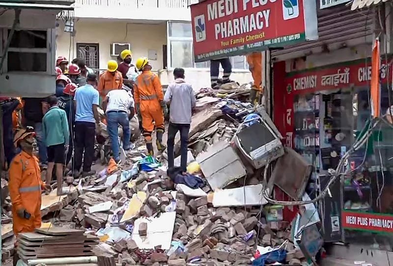 इमारत के मलबे के बीच बचाव कार्य में जुटे राहतकर्मी