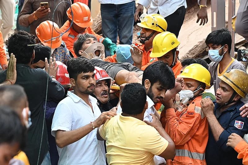 एक व्यक्ति को स्ट्रेचर पर ले जाते बचावकर्मी