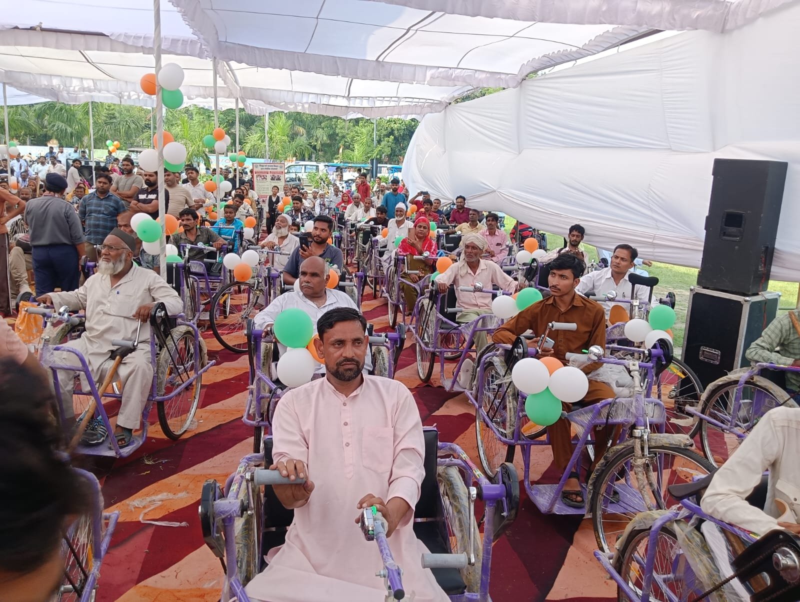 मुजफ्फरनगर में सहायक उपकरण वितरण कार्यक्रम के दौरान ट्राईसाइकिलों पर लाभार्थी